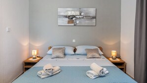 Une chambre d’hôtel avec un lit, deux lampes de chevet, une œuvre d’art murale et des serviettes sur le lit.