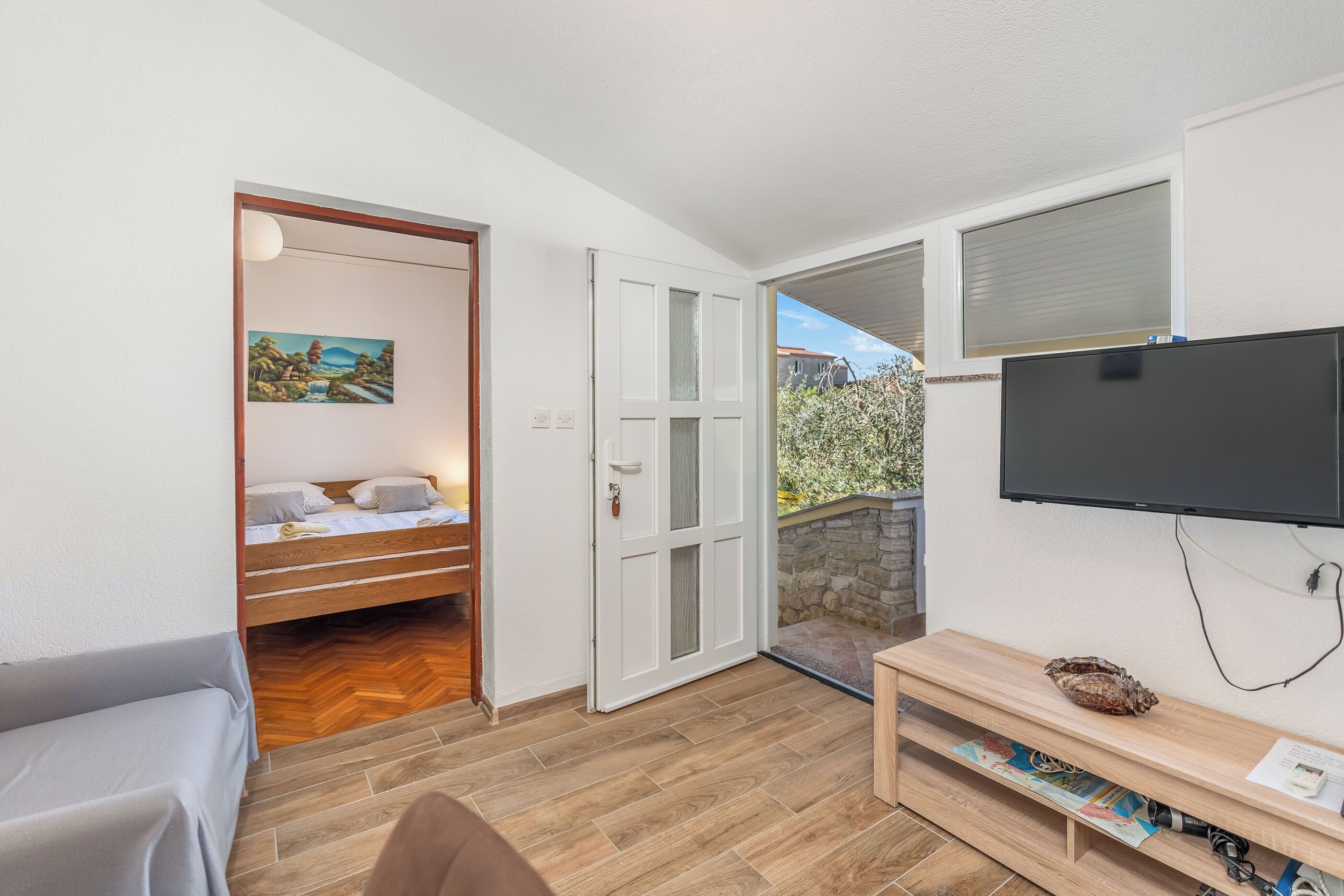A room with a bed, a TV, and a small table.