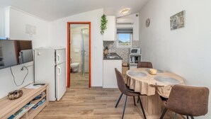 Une cuisine compacte avec un coin repas, un téléviseur et un réfrigérateur.
