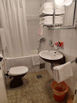 Casa de banho com sanita, lavatório e zona de duche.