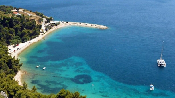 An aerial view of a coastal area with a beach, boats, and a sailboat. - Apartment Brane (Split)