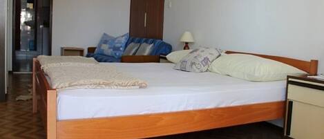 A bedroom with a wooden bed, a nightstand, a lamp, and a wardrobe.
