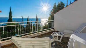 A balcony with white chairs and a view of the sea. - Apartments Mari (Dugi Rat)