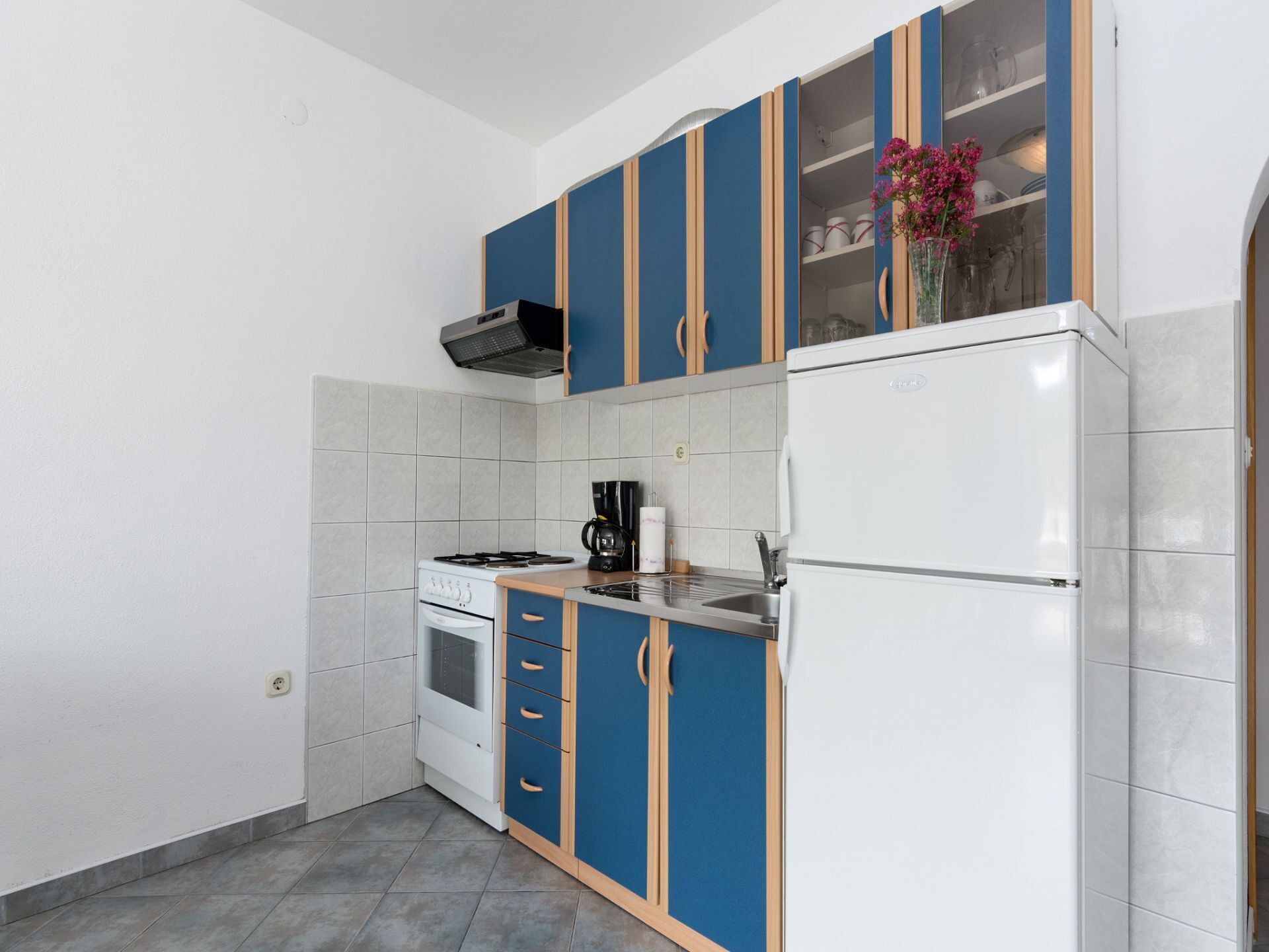 A compact kitchen with a stove, sink, and refrigerator.