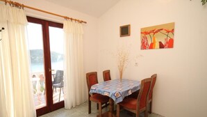 Zona pranzo con tavolo ricoperto da tovaglia blu, circondato da sedie in legno.