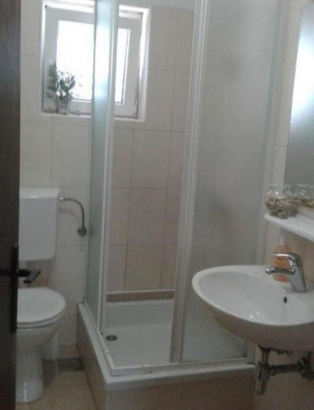 Une salle de bain comprenant des toilettes, un espace douche et un lavabo.