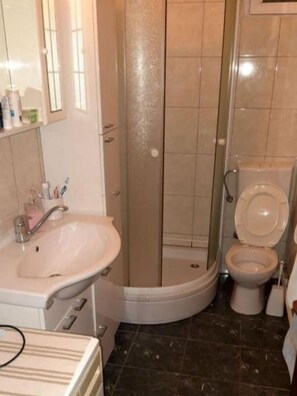 A bathroom with a sink, toilet, and shower. - Apartments Marija (Supetar)