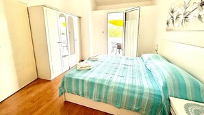Een slaapkamer met een bed, een deur en een raam.