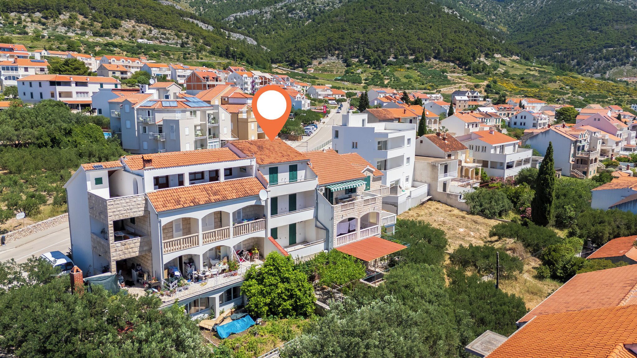 Un barrio residencial con edificios de varios pisos, una piscina y un paisaje montañoso al fondo.