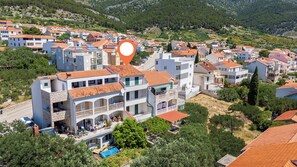 Μια οικιστική περιοχή με πολυώροφα κτίρια, μια πισίνα και ένα λόφωμα στο βάθος.