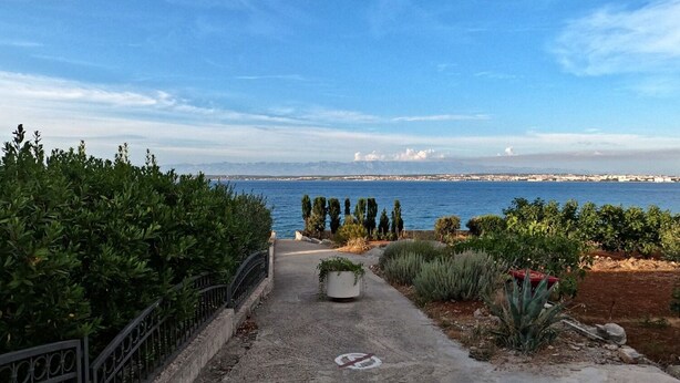 A pathway leading to a scenic view of the sea with a clear sky. - Apartment Mili (Preko)