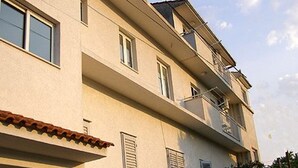 Un edificio de varios pisos con fachada plana, varias ventanas y un balcón en el nivel superior.
