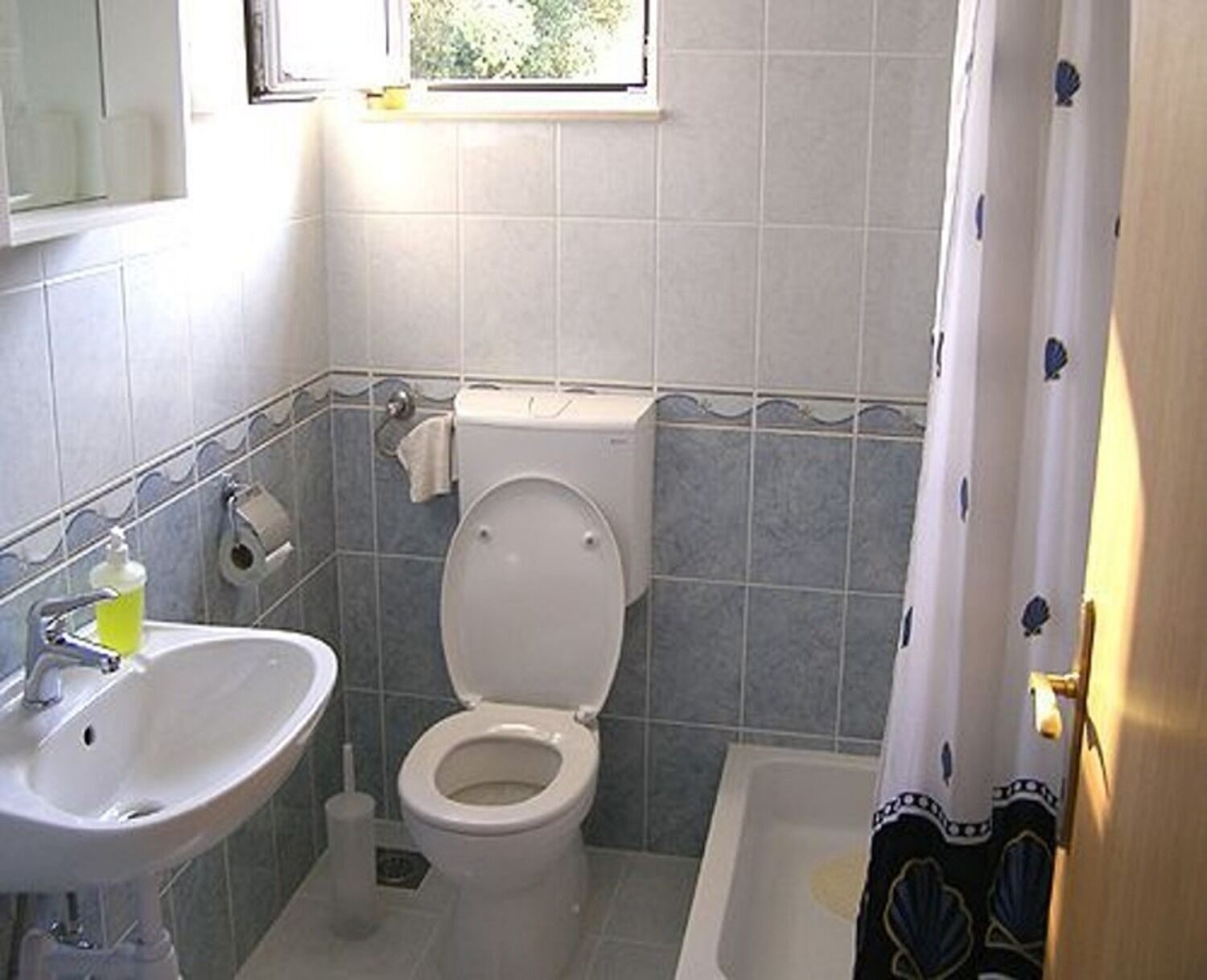 A bathroom with a toilet, sink, and bathtub.