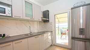 Una cucina moderna con un frigorifero in acciaio inossidabile, un forno a microonde e un lavello.