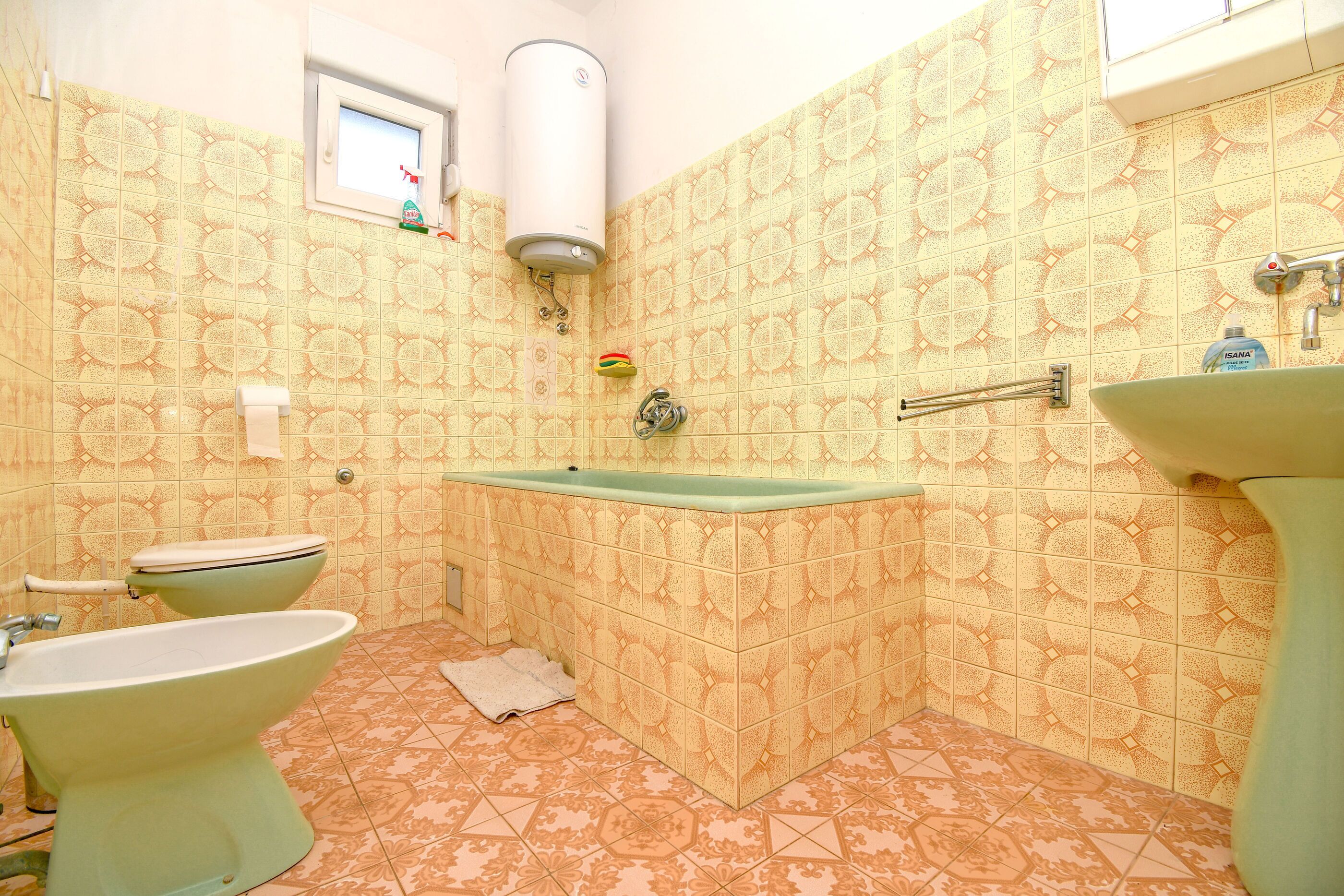 A bathroom with a toilet, bidet, and bathtub.