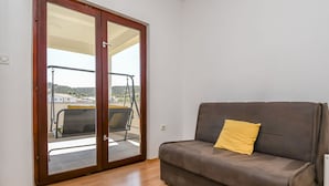 Ein Zimmer mit einer Schiebetür und einem Balkon mit einer Schaukelstuhls.