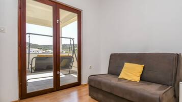 A room with a sliding glass door leading to a balcony with a swing chair.