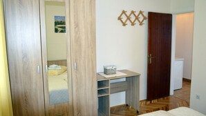 Ein Schlafzimmer mit Kleiderschrank, Schreibtisch und Bett.