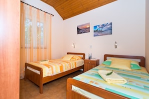 A bedroom with two single beds, wooden headboards, a wooden ceiling, a window with sheer curtains, and two wall-mounted lights. - Apartment Mirja (Solta)