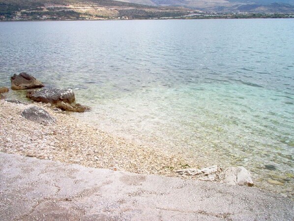 A clear lake with a pebbly shore and visible rocks. - Apartments Anda (Trogir)