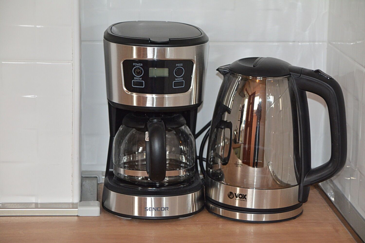 A coffee maker with a digital display and a glass carafe.