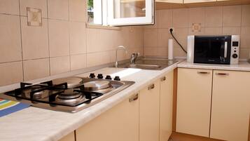 Departamento (A2) | Cocina privada | Refrigerador, microondas, parrilla de estufa y utensilios de cocina