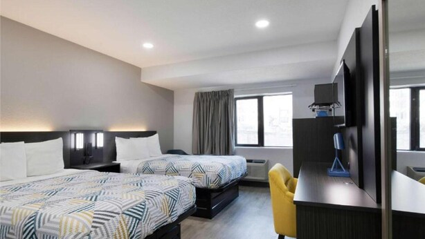 A hotel room with two beds, a desk, a chair, a TV, and a window with curtains. - 2 Full Beds|Mobil Access|Nsmk|Micfridg (Atlanta)