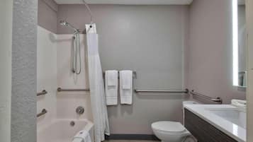 A bathroom with a bathtub, toilet, and a shower area.