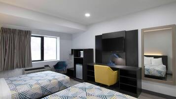 A hotel room with two beds, a desk, a chair, a TV, and a mirror.