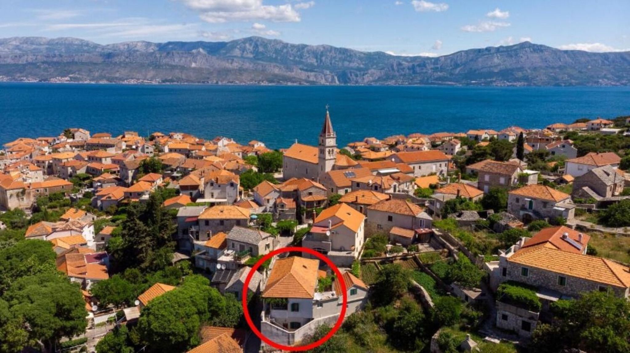 A coastal town with traditional architecture, a prominent church, and a view of the sea.