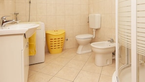 A bathroom with a sink, toilet, bidet, and shower. - Apartments Brane (Postira)