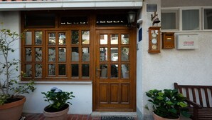A wooden door with glass panels, a bench, and potted plants. - Apartment Maria (Split)