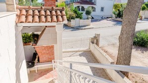 Un immeuble résidentiel doté d’un toit en tuiles, d’un mur en briques et d’un escalier menant à un étage supérieur.