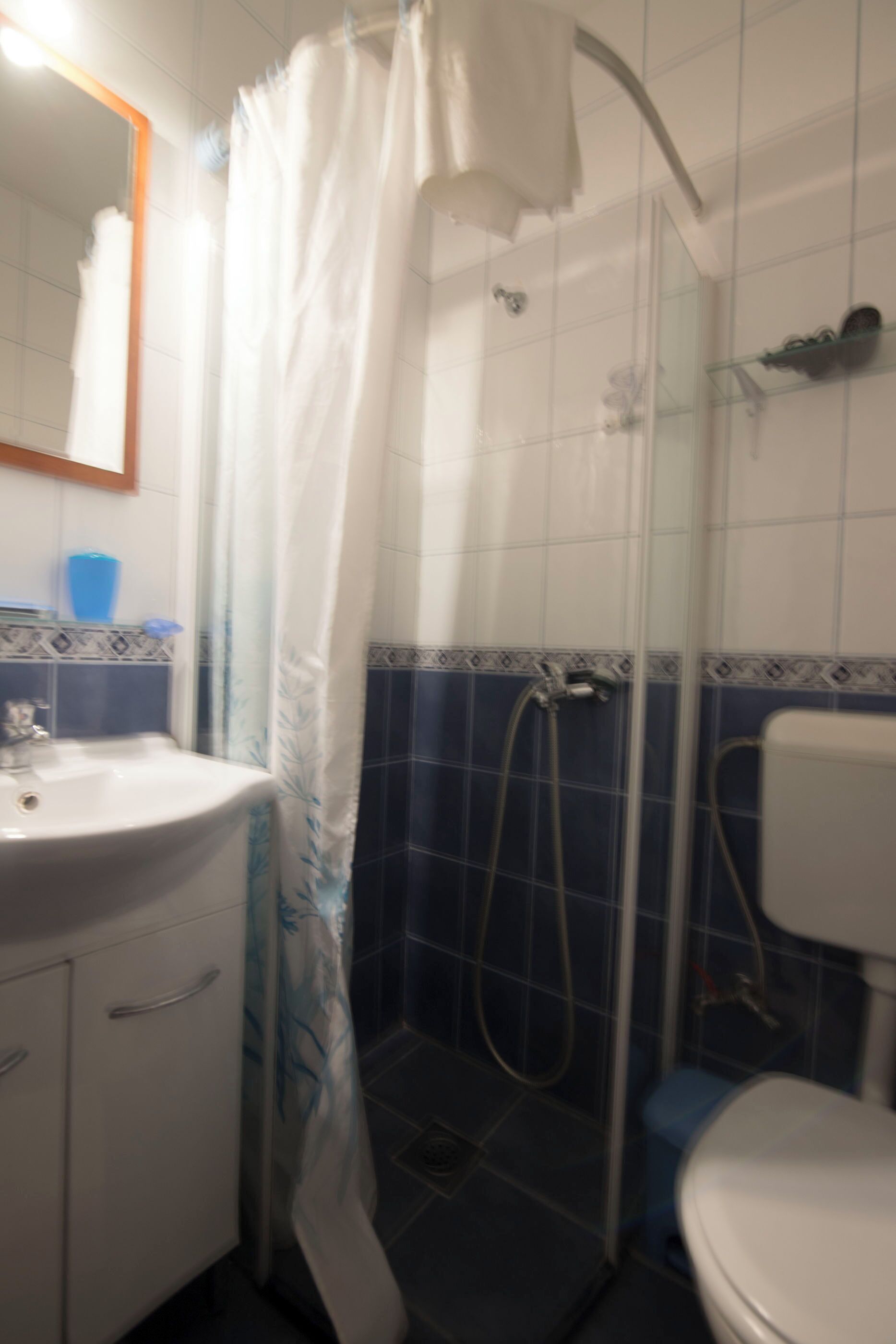 A bathroom with a shower, a sink, and a toilet.