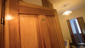 Una porta in legno con una targa, una ventola a soffitto e una finestra con persiane.