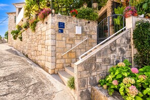 A stone staircase leading to an apartment entrance with a sign indicating it is a 6th floor apartment. - Apartments Kat (Supetar)