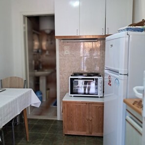 A compact kitchen with a microwave, a toaster, and a refrigerator. - Apartments Kat (Supetar)