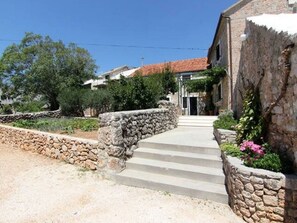 A stone staircase leading to a building with a tiled roof. - Apartments Matej (Bol)