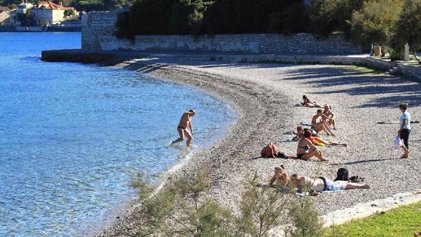 A pebble beach with people sunbathing and swimming. - House Paulo1 (Vis)