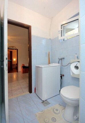 A small bathroom with a toilet, a sink, and a white heater. - Apartments Roki (Vis)