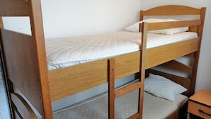 A bunk bed with a wooden frame, a mattress, and pillows. - Apartments Branko (Vis)