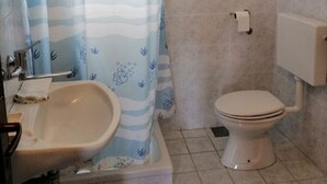 A bathroom with a bathtub, a sink, and a toilet. - Apartments Branko (Vis)