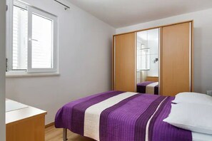A bedroom with a bed, a wardrobe, a desk, and a window. - Apartment Ljilja (Hvar)