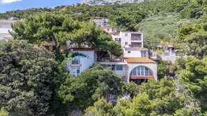A hillside residential area with houses featuring balconies and a mix of architectural styles. - Apartments Marko (Omis)