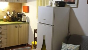 Una cucina compatta con tavolo, sedie, frigorifero e forno a microonde.
