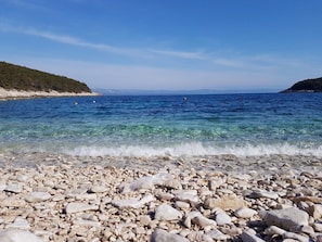 A pebbly beach with clear water and distant hills. - House Villa Bistrana (Vela Luka)