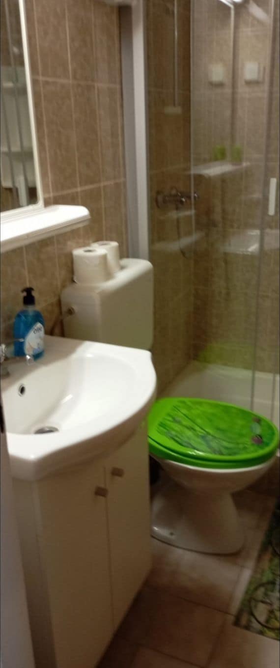 Baño con lavamanos, inodoro y ducha blancos.