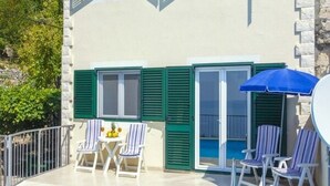 A two-story building with a swimming pool, outdoor seating, and a mountain backdrop. - House Ned (Tucepi)