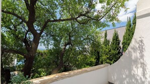 Ein Balkon mit Blick auf Bäume und ein Gebäude.