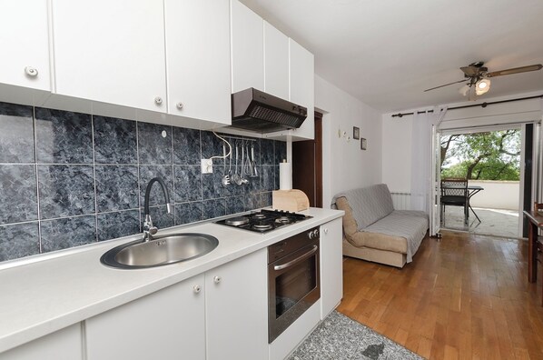 A modern kitchen with a built-in oven, a sink, and a stove. - Apartments Ema (Murter-Kornati)